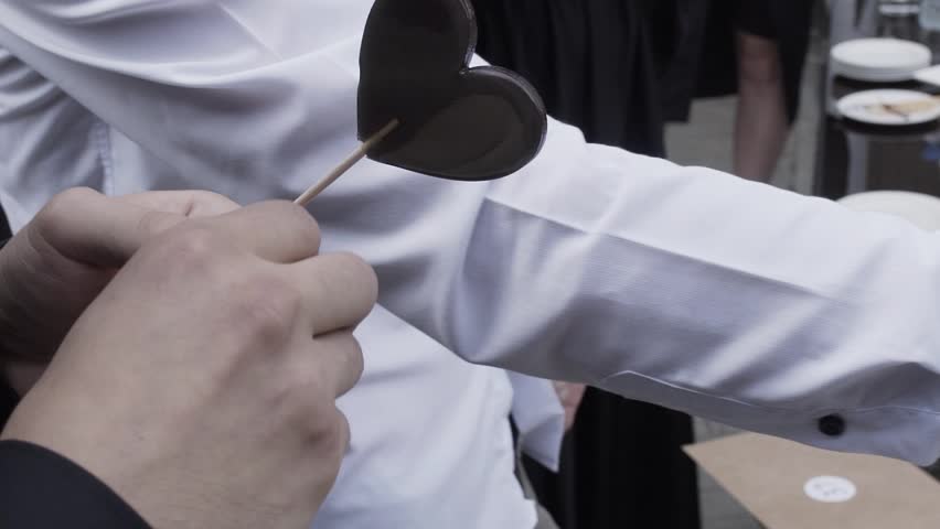 A young man opens a ball from a lottery drum and looks at a piece of paper with a number