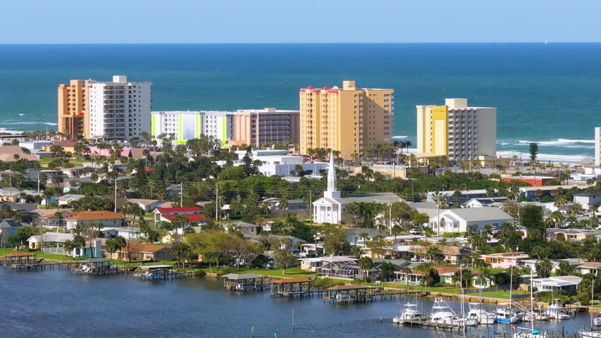 Daytona Beach city with waterfront houses, high-rise hotels and apartments. View from above of coastal Florida neighborhood. Development of US housing