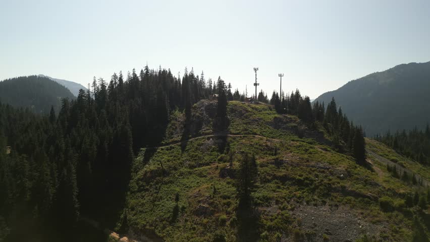 Aerial above mountain peak at top of Snoqualmie Pass in Washington with radio tower