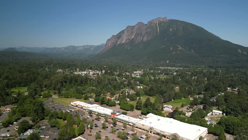 Aerial above shops in North Bend Washington in summer below Mount Si
