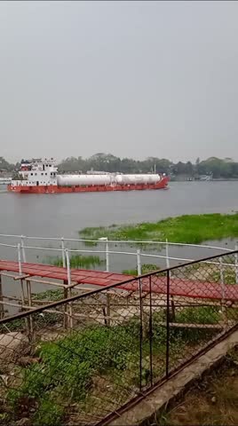 Different Objects along with natural nice scenes are seen on the both side of River and a modern Cargo ship is going through the river. Video clip taken in Bangladesh 
