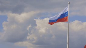 Flag of Russian Federation is flying in air on blue sky and white cumulus clouds. National flag of Russian. shot handheld. High quality 4k footage - Powered by Shutterstock - Get 15% off with code: PIKWIZARD15