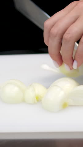 Close-up. cut onions Chef chopping an onion with fine pressure on a cutting surface in professional kitchen