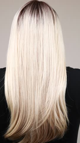 Vertical slow motion video of unrecognizable model with long blond straight hair