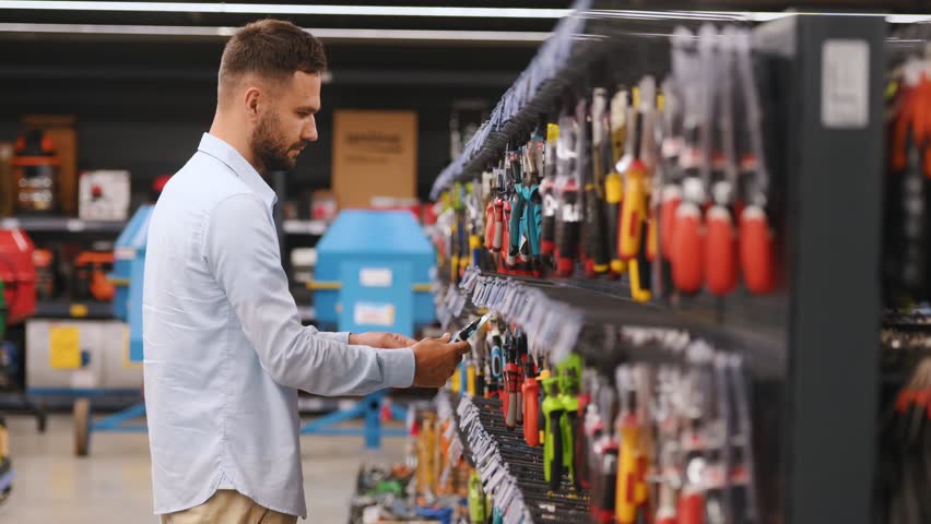 A customer in a hardware store chooses tools