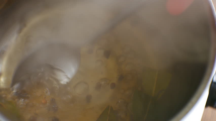 Chef Prepares Flavorful Marinade for Fish and Other Seafood. Stirring Vigorously with Spoon in Small Steel Pan. Cinematic Kitchen Shot