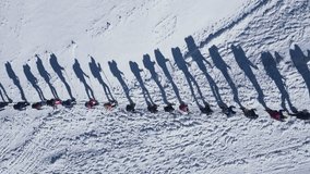 A group of people climbs a snowy mountain slope, filmed from a drone. - Powered by Shutterstock - Get 15% off with code: PIKWIZARD15