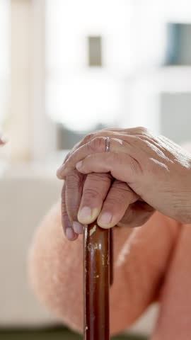 Helping hand, caregiver and empathy for support with kindness in nursing home for retirement. Elderly person, cane and senior care in bonding with nurse, connection and together in health or wellness
