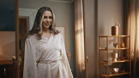 Joyful woman mirror reflection at living room zoom out. Excited happy lady spinning around sending air kiss at bedroom. Smiling positive model in silk robe having fun before work in light apartment - Powered by Shutterstock - Get 15% off with code: PIKWIZARD15