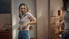 Dieting woman trying clothes big jeans at home. Excited happy girl look mirror admiring fitness slimming results in sunny bedroom. Cheerful sporty model analyzing shape. Healthy lifestyle motivation  - Powered by Shutterstock - Get 15% off with code: PIKWIZARD15