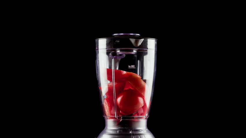 Photography for dynamic scenes, slicing, a bunch of tomatoes being chopped in a transparent blender, some pieces scattering and splashing the tomato juice