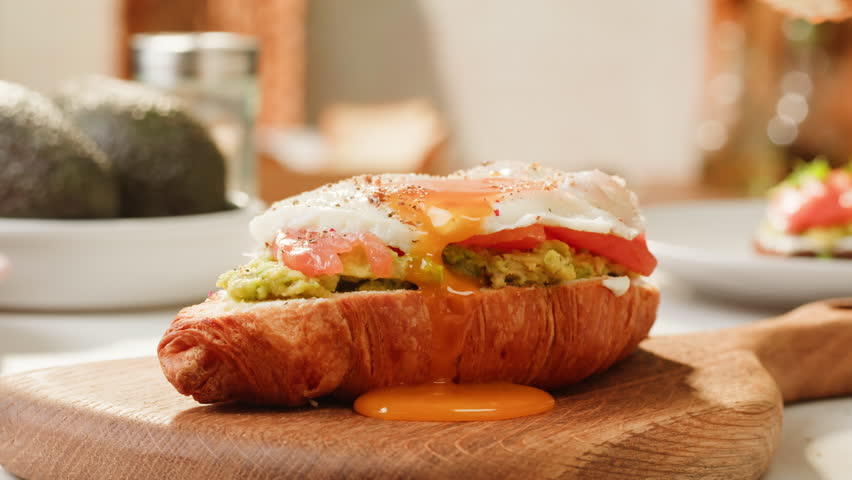 Delicious Croissant Sandwich made with Egg and Avocado and salmon, traditional french cuisine, france cafe, morning breakfast brunch menu. 