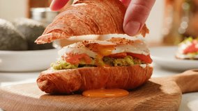 Delicious Croissant Sandwich made with Egg and Avocado and salmon, traditional french cuisine, france cafe, morning breakfast brunch menu.  - Powered by Shutterstock - Get 15% off with code: PIKWIZARD15