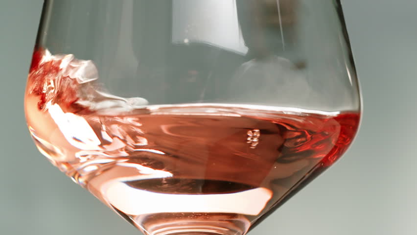 Rose Orange or white wine bottle and glass against a sunset in a peaceful vineyard, pouring of ecological natural wine. Cheers, hands with wine glasses, drinking alcohol.