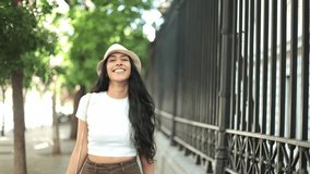Slow-motion video of a young Latina woman with long dark hair shopping in the city, smiling as she walks with shopping bags in hand, enjoying her day. - Powered by Shutterstock - Get 15% off with code: PIKWIZARD15
