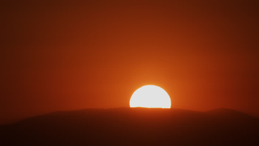 Extreme Closeup of Sun Rising Over a Hill into a Red Sky 4K Zoom Out Timelapse.