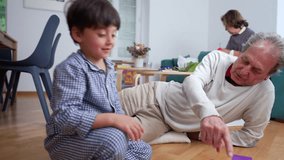 Grandfather and grandson playing memory cards on the floor, engaging in fun and educational bonding activity, highlighting intergenerational connection, family interaction, and shared learning - Powered by Shutterstock - Get 15% off with code: PIKWIZARD15