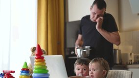 Children play with toys in kitchen while dad prepares breakfast. Dad and children at home. family laughing cooking. Family morning children's games and breakfast preparation come together in harmony. - Powered by Shutterstock - Get 15% off with code: PIKWIZARD15