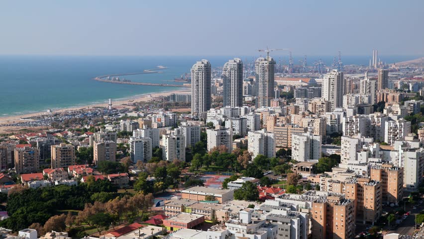 A city Ashdod view from a high building with many tall buildings and a large body of water in the background. High quality 4k footage