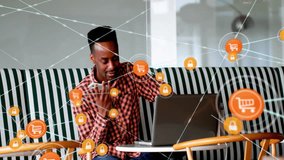 Using laptop, man surrounded by e-commerce and security icons animation. Technology, online shopping, cybersecurity, internet, digital, safety - Powered by Shutterstock - Get 15% off with code: PIKWIZARD15