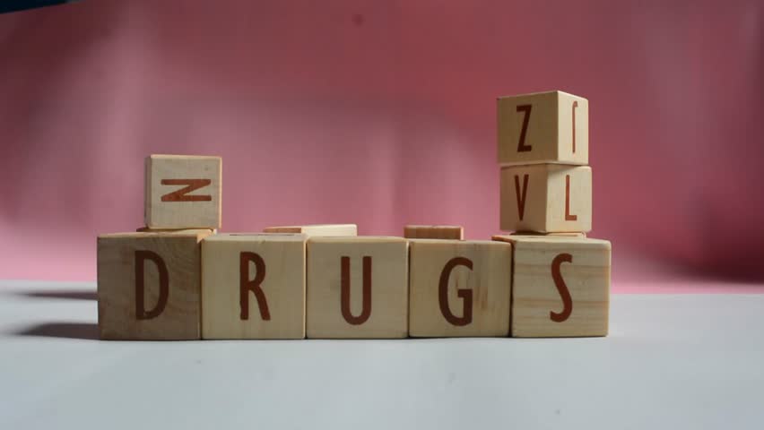 DRUGS word written on wood block. Content text on wooden table for your desing, concept.