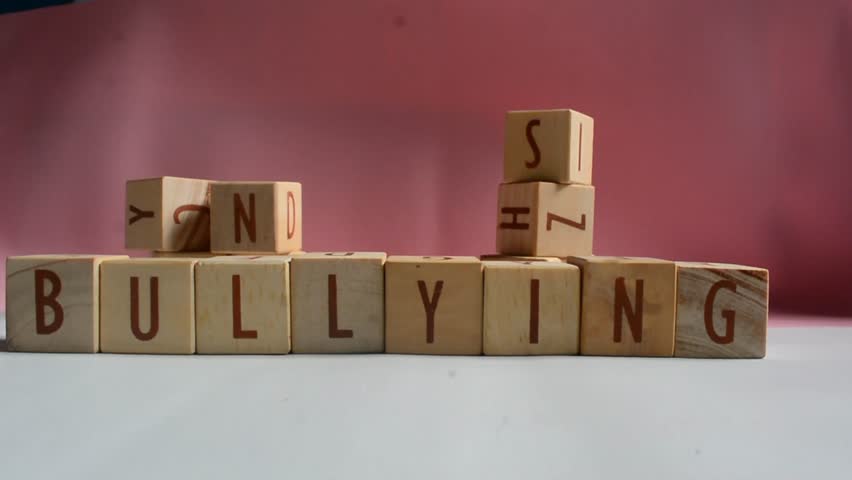 BULLYING word written on wood block. Content text on wooden table for your desing, concept.