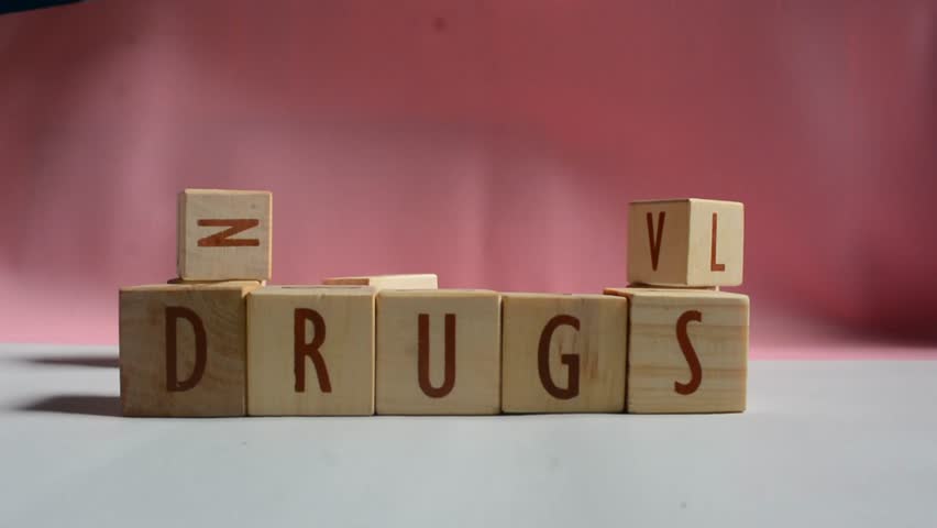 DRUGS word written on wood block. Content text on wooden table for your desing, concept.