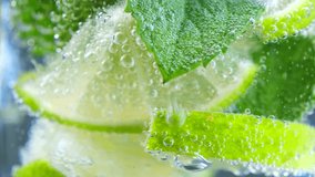 Fizzing of sparkling water with lime and mint falling into glass. Sense of cool refreshment ideal for hot day thirst-quenching during summer - Powered by Shutterstock - Get 15% off with code: PIKWIZARD15