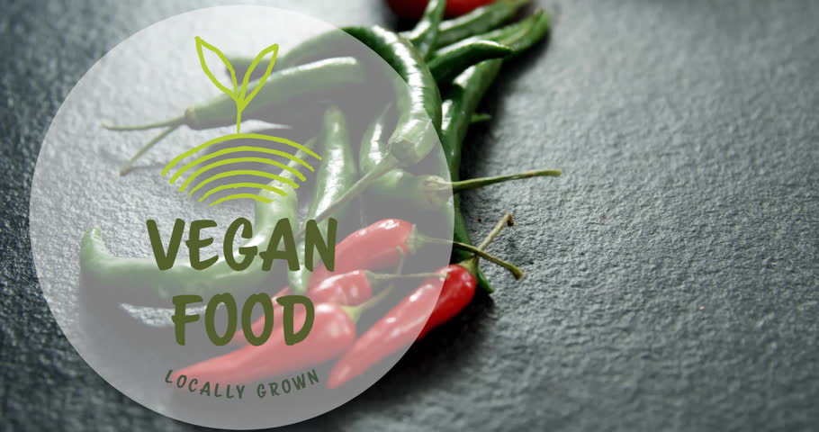 Vegan food logo animation over fresh green and red chili peppers. organic, health, spicy, vegetarian, branding, marketing