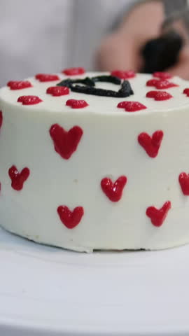 cake with red hearts pastry chef decorates a cake with red heart-shaped cream for Valentine