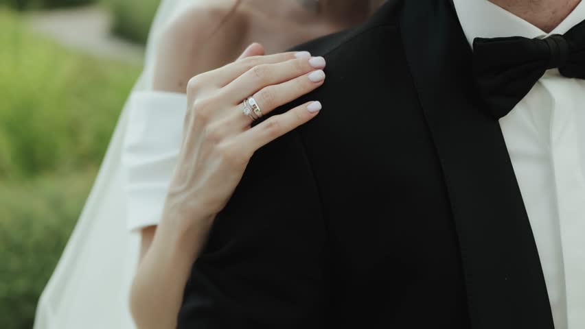 Elegant wedding video with bride and groom hugging, showing off ring