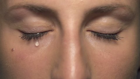 SLOW MOTION CLOSE UP: Tear comes out of an eye and streaks down the cheek. Sad abused female with brown eyes crying Stock Video