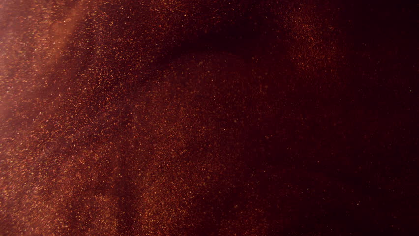 Shimmering sparks. Smoke splash. Ink water. Blur red bronze golden color mist sparkling particles texture paint flow on dark black abstract art background.