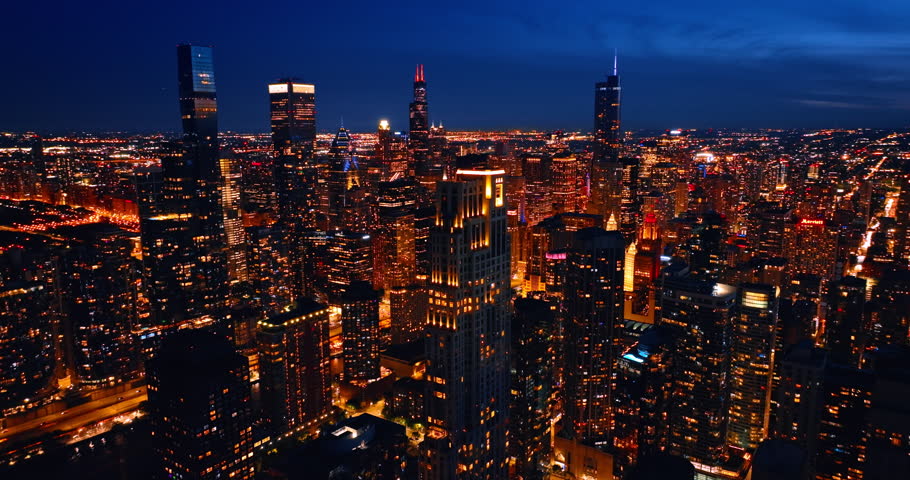 Light streets and buildings of modern Chicago at night. Thriving vibrant metropolis view from top.