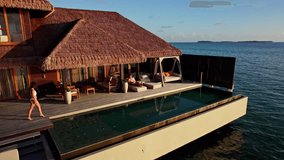 Couple relaxing in a bungalow on the water in the Maldives - Powered by Shutterstock - Get 15% off with code: PIKWIZARD15