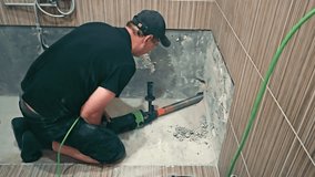 Worker Drilling in a Bathroom Renovation, A construction worker in a black shirt and cap is using a power drill to renovate a bathroom - Powered by Shutterstock - Get 15% off with code: PIKWIZARD15