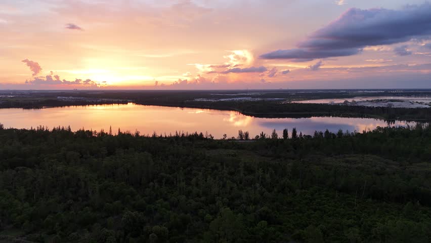 Gorgeous sunset with cotton candy skies over Florida lakes in Fort Myers. Drone footage above Southwest Florida