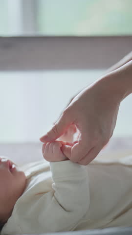 Close-up little hand of child baby holding hand of mother, A newborn holds on to mom's, dad's finger, Love and relationship with infant, Care and support, Dreaming and protection