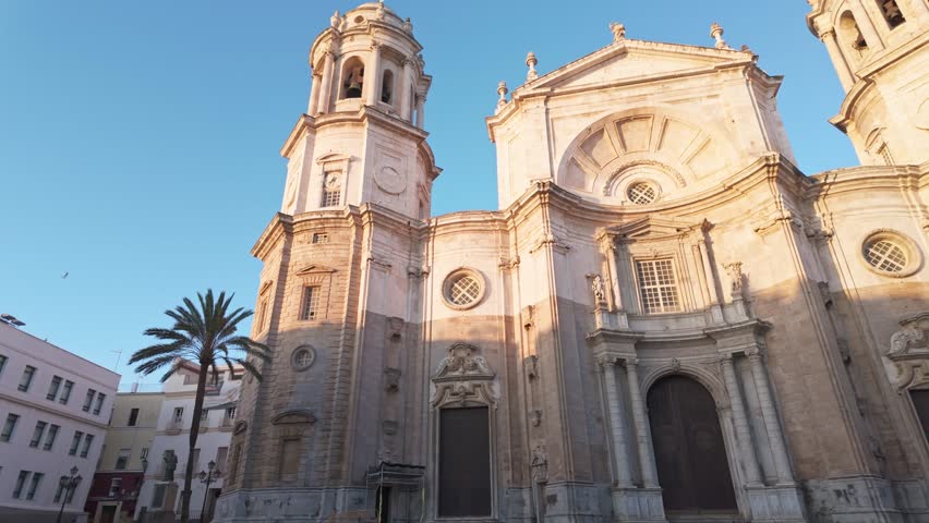 Cadiz Cathedral facade surrounded by palm trees in Andalusia, Spain