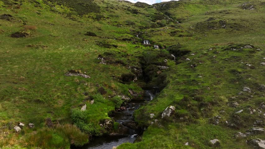 Ireland Waterfall flowing through the Irish hillside off the clear mountainside