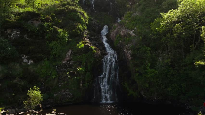 Ireland Waterfall flowing through the Irish hillside off the clear mountainside