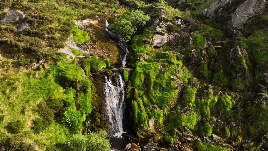 Ireland Waterfall flowing through the Irish hillside off the clear mountainside