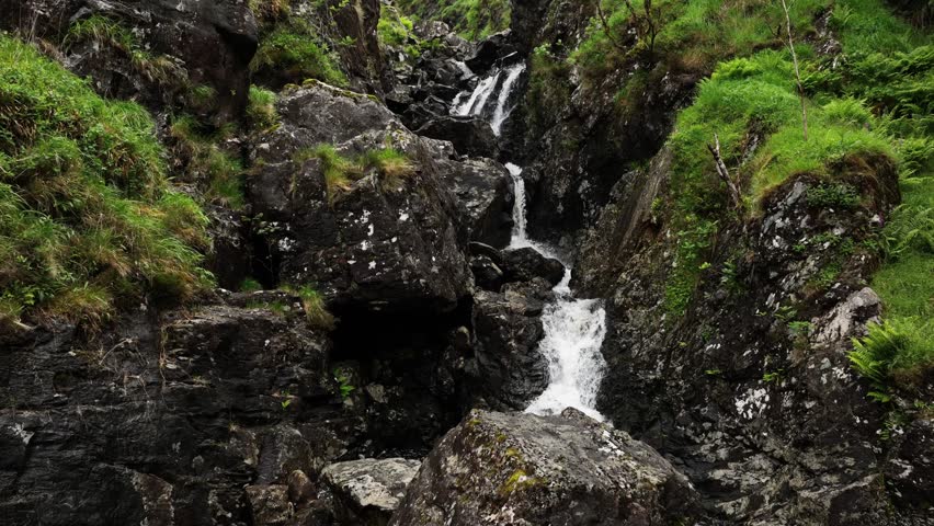 Waterfall flowing through narrow canyon in the Irish hillside