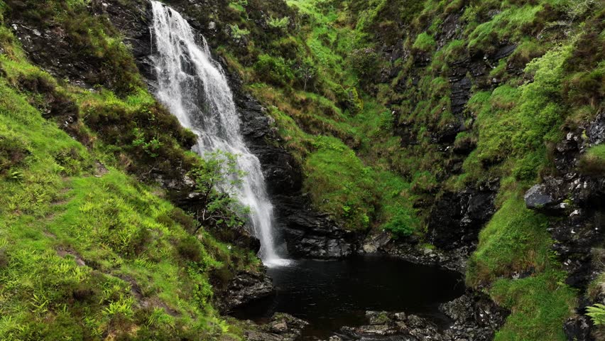 Waterfall flowing through the Irish hillside big cascade green