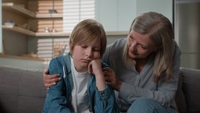 Loving senior mature Caucasian elderly 50s woman granny female touch calming offended stressed bored little kid boy child son grandson sofa grandmother parent ask forgiveness cheering up talk hug home - Powered by Shutterstock - Get 15% off with code: PIKWIZARD15