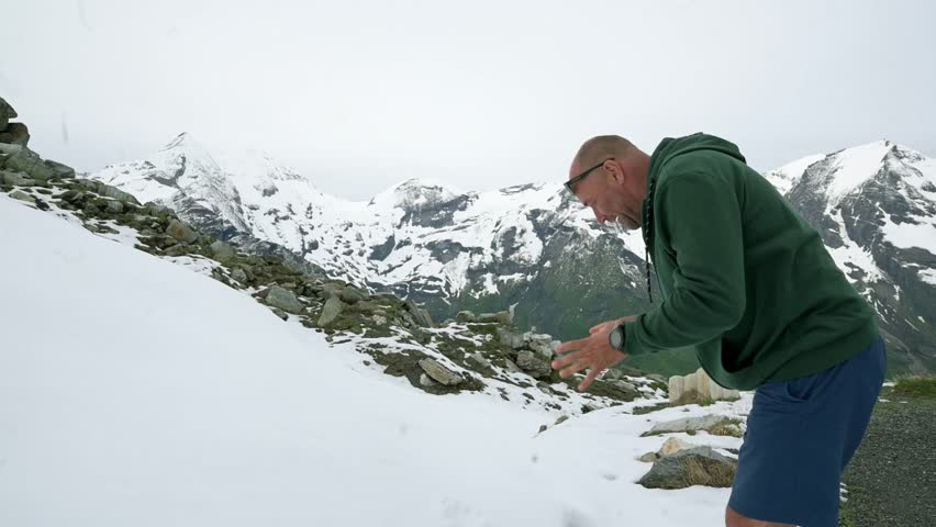 A man enjoys the snow on a mountainside in the Grossglockner region of Austria. The snow-capped peaks and rugged terrain provide a stunning backdrop for outdoor adventure.