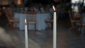 Two lit candles with blurred banquet tables and chairs in the background - Powered by Shutterstock - Get 15% off with code: PIKWIZARD15