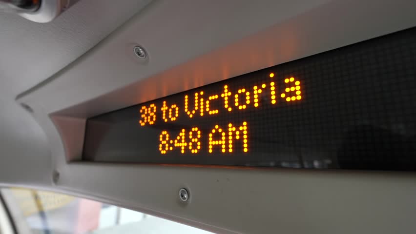 A digital display inside a city bus shows the route 38 to Victoria at 8:48 AM, This technology enhances the commuting experience by offering real-time updates on the route and schedule.