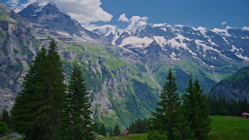 Establishing shot of the beautiful Swiss nature and village in Switzerland. Footage of idyllic swiss village sunny day. Wide view of Swiss Alps. Switzerland summer tourism destination