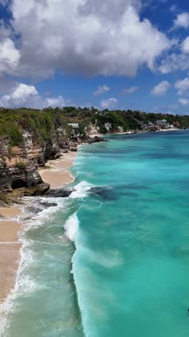 Dreamland Beach in Bali is a surfer's paradise with white sand, clear turquoise waters, and rugged cliffs. Known for its consistent waves and stunning ocean views.